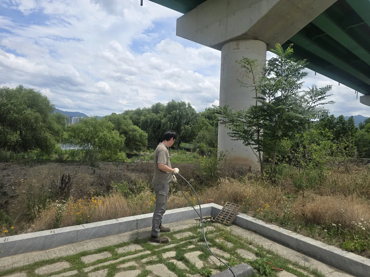 세척이 끝난 배관 내부에서 기름때가 제거된 상태를 확인하는 작업자
